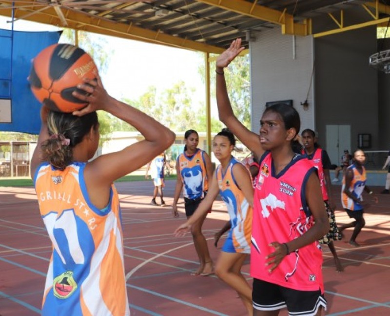 Two indigenous girls playing basketball