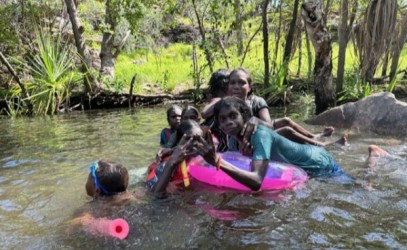 Children enjoying a waterfall party with rubber rings and noodles