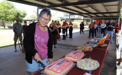 Smiling lady cutting a cake 