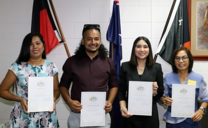 Four new citizens proudly displaying their certificates