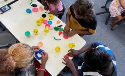 Children enjoying the school holiday program making playdoh