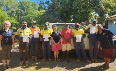 Warruwi team photo standing out the front of a car