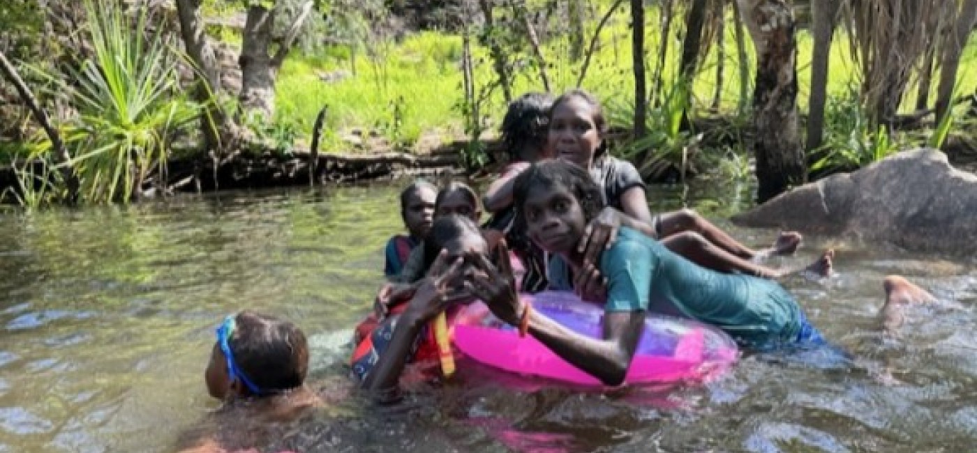 Children enjoying a waterfall party with rubber rings and noodles