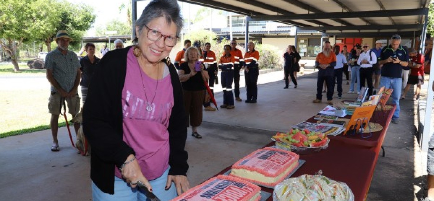 Smiling lady cutting a cake 