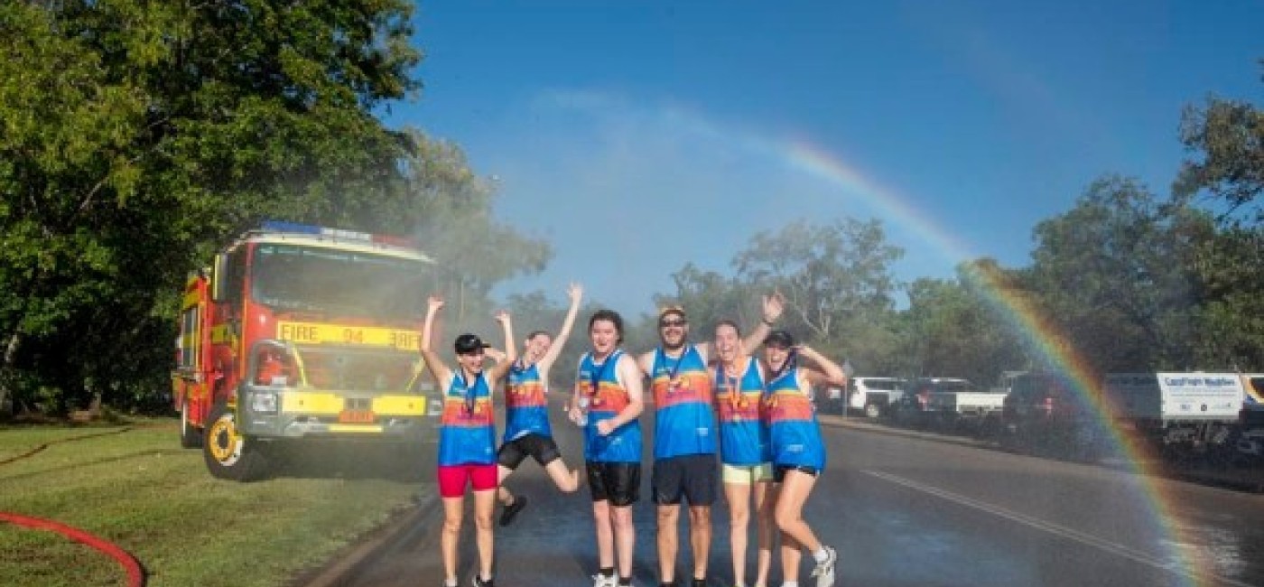 Participants of the Kakadu Triathlon celebrate their accomplishment under a refreshing water spray