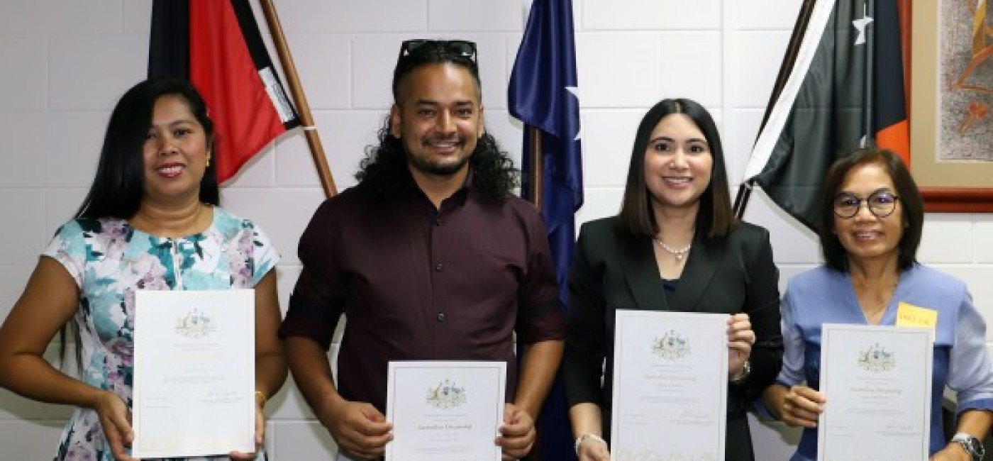 Four new citizens proudly displaying their certificates