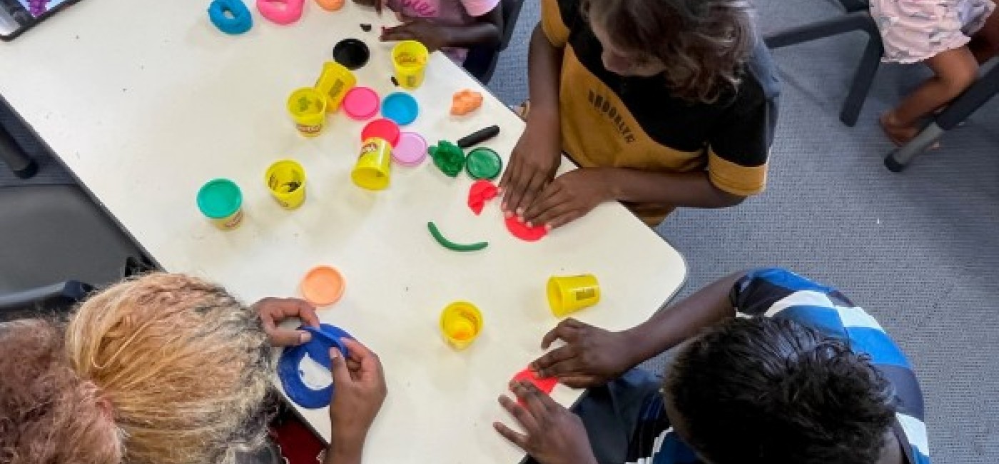 Children enjoying the school holiday program making playdoh