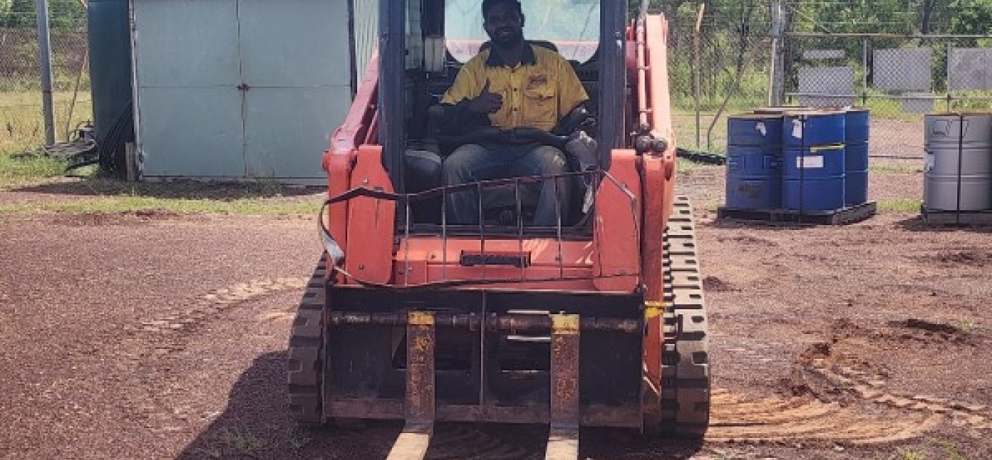 Man on a bob cat smiling 